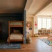 Beautifully zoned shared kids bedroom featuring distinct sleep and play areas with modern decor