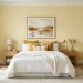 Beautiful guest bedroom with sunny yellow accent wall and crisp white bedding flooded with natural light.