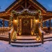 Glowing winter porch completely decorated with warm white fairy lights in the snow at twilight