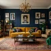 Wide view of an eclectic living room with a mustard velvet sofa against dark navy blue walls.