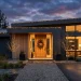 Minimalist outdoor Christmas decorations enhancing a modern home's curb appeal at dusk.