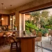 Seamless indoor-outdoor home bar with sliding windows and patio seating at sunset