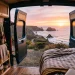 Cozy boho camper van interior with rattan cabinets and wicker baskets facing a coastal sunset