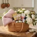 Luxurious Mother's Day gift basket on an oak kitchen island filled with chocolates, a plush blanket, and white peonies.