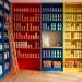 A vibrant kitchen pantry featuring red, blue, and yellow shelves neatly organizing food cans.