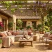 Sun-drenched backyard patio featuring warm clay accents, terracotta planters, and comfortable outdoor seating.