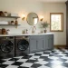 A modern laundry room featuring a bold black and white checkered floor and sleek appliances