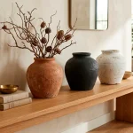 Three textured DIY faux vintage vases sitting on a modern wooden entryway table