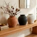 Three textured DIY faux vintage vases sitting on a modern wooden entryway table