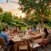 Beautiful backyard patio featuring a wooden dining table and stylish space-saving folding outdoor chairs under warm string lights