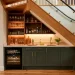 Beautifully designed built-in mini bar under a modern wooden staircase with LED lighting and a wine fridge
