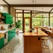 Wide panoramic view of a mid-century modern kitchen featuring emerald green cabinets and warm teak wood accents.