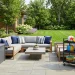 Beautifully organized modern backyard patio featuring a sleek resin deck box and a rolling utility cart for outdoor play items