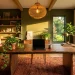 Wide view of an earth tone sanctuary home office featuring terracotta walls, a walnut desk, and soft ambient lighting.