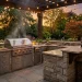 Luxurious outdoor backyard kitchen with stone countertops and a built in grill at golden hour