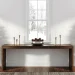 Perfectly symmetrical winter entryway table featuring tall frosted pine trees and brass candlesticks.