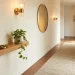 Beautifully styled tiny modern entryway with a floating oak shelf, warm sconces, and a textured runner rug