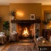 Cozy ochre living room featuring a warm fireplace styled with dark wood, brass, and woven baskets.