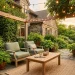 Cozy outdoor patio featuring muted sage green lounge chairs, teak wood table, and warm ambient string lights at sunset.