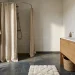 Warm Scandinavian bathroom with waffle towels on an oak stool and a beige linen shower curtain.