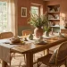 Cozy dining room interior featuring earthy terracotta walls and a raw oak wood table with rattan chairs.