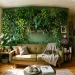 Lush vertical plant wall above a modern sofa in a bright micro studio apartment
