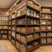 Beautifully organized deep pantry with clear storage bins and warm lighting