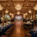 Wide view of a luxurious navy and gold wedding reception in a classic ballroom.