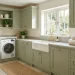Beautifully organized laundry room featuring sage green solid wood cabinets and brass hardware