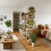 A beautifully styled small studio apartment featuring a wooden bookshelf divider and cozy living area.