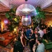 Wide view of a moody living room lit by a spinning mushroom disco ball hanging from the ceiling