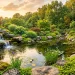 Lush backyard pond featuring natural rock placement and a cascading waterfall at sunset