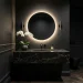 Luxurious monochrome black powder room featuring matte dark walls, backlit circular mirror, and sleek black marble vanity.