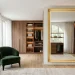 Wide view of a modern luxurious dressing room with a clean glowing floor mirror and rich wood cabinets.