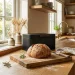 Elegant artisan bread bin next to a fresh sourdough loaf on a warm kitchen counter
