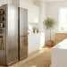 Clean modern kitchen showing magnetic organization racks attached to a stainless steel refrigerator.